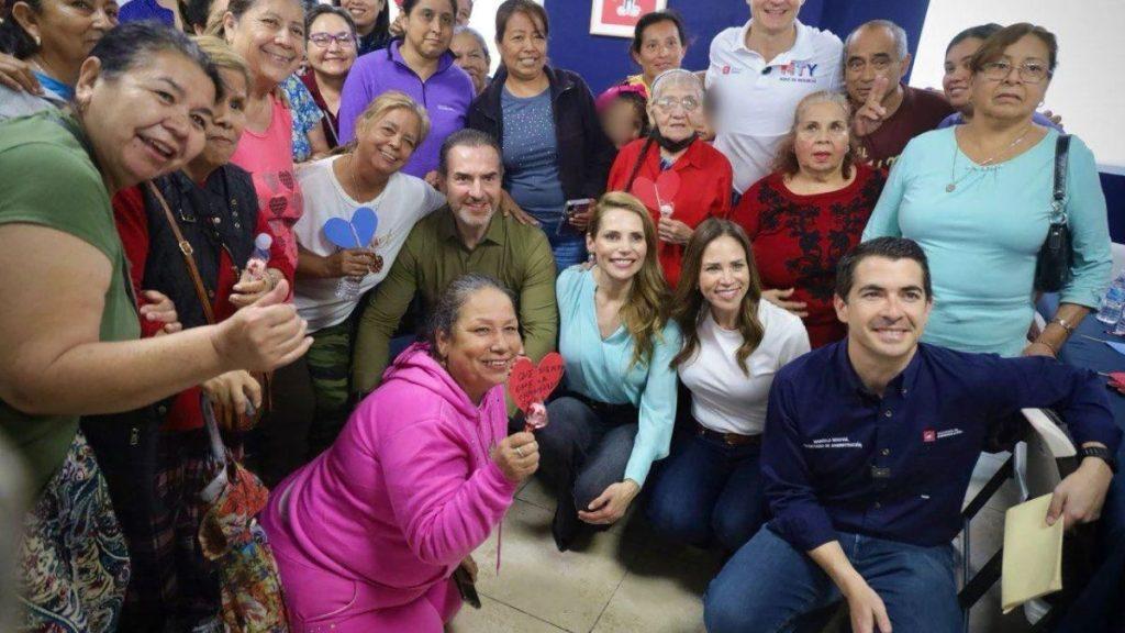Group of diverse volunteers posing for a group photo at a community event some holding red heart cutouts and smiling joyfully   Informe Regio