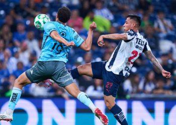 Two soccer players leap for a ball in midair during a match one in light blue and the other in a whiteblue striped kit with a crowd in the background   Informe Regio