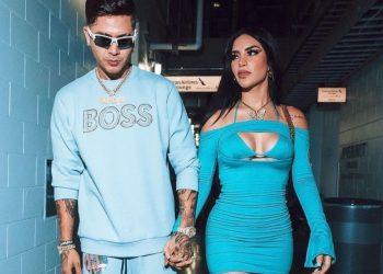 A man and a woman walk down a blue lit hallway holding hands and wearing matching blue outfits   Informe Regio