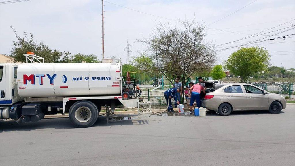 Water tanker labeled MTY on a street with people filling containers from a hose beside a beige car   Informe Regio