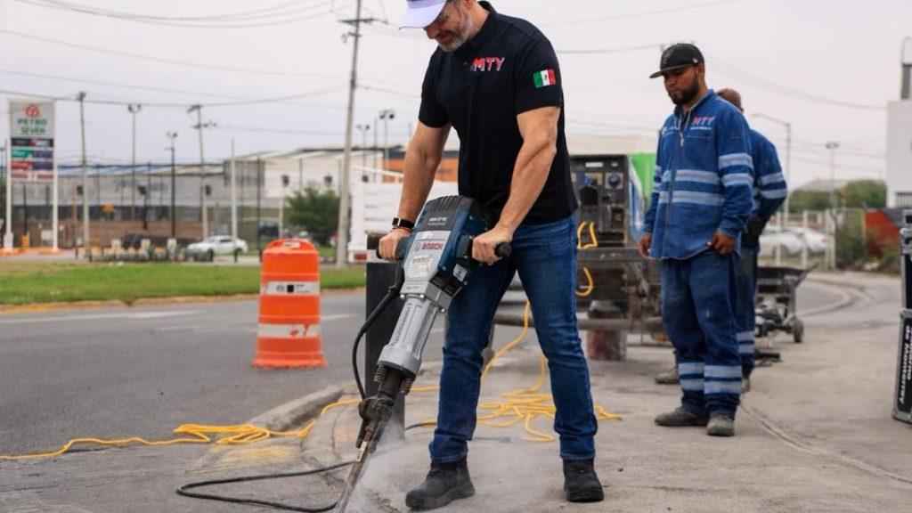Adios-a-los-topes-altos-en-monterrey - Informe Regio Road construction a worker in a black shirt uses a jackhammer on asphalt while another worker watches nearby orange traffic barrel in the background Informe Regio