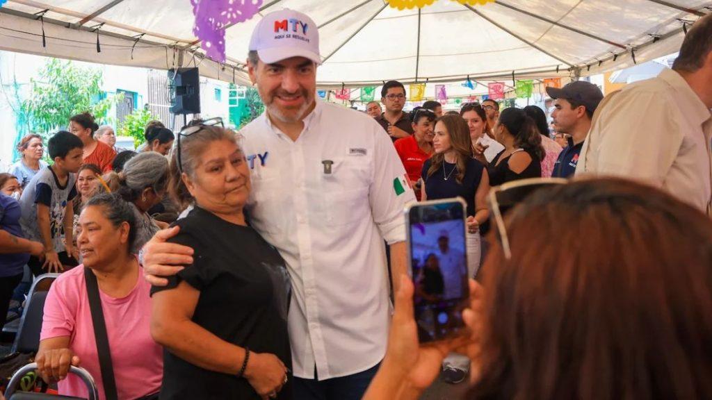 Man in a white shirt and hat hugs a smiling woman at a crowded outdoor event under a decorated tent   Informe Regio