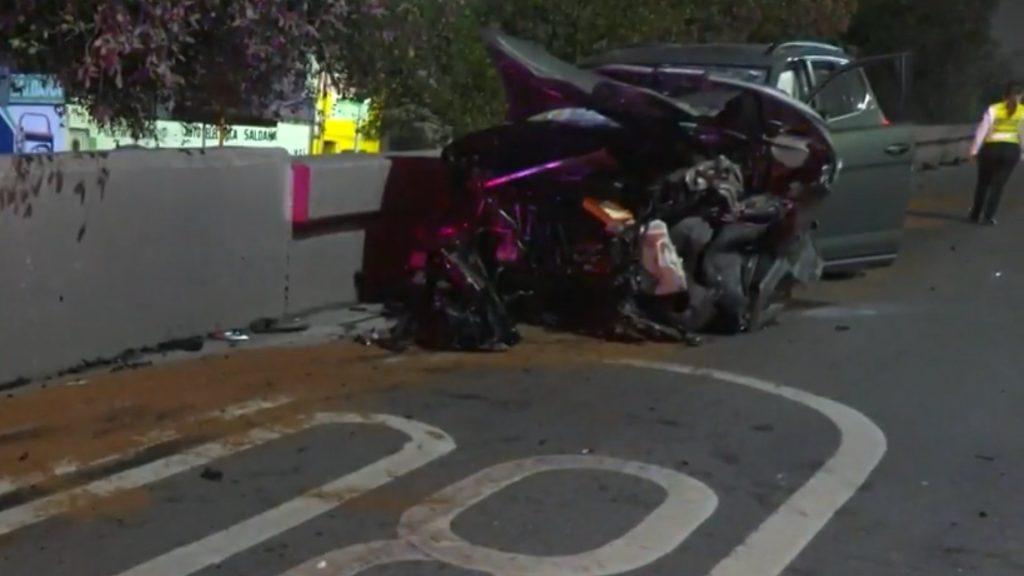 Crushed car crash at a barrier with debris on the road and a person wearing a high visibility vest nearby   Informe Regio
