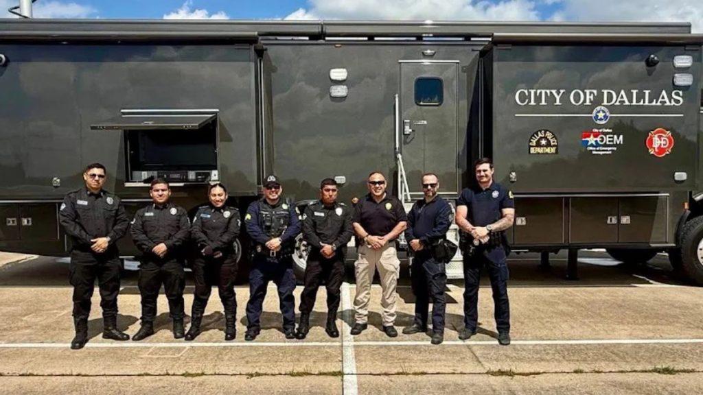 Group of City of Dallas police and security personnel posing in front of a large black mobile command trailer marked CITY OF DALLAS on the side   Informe Regio