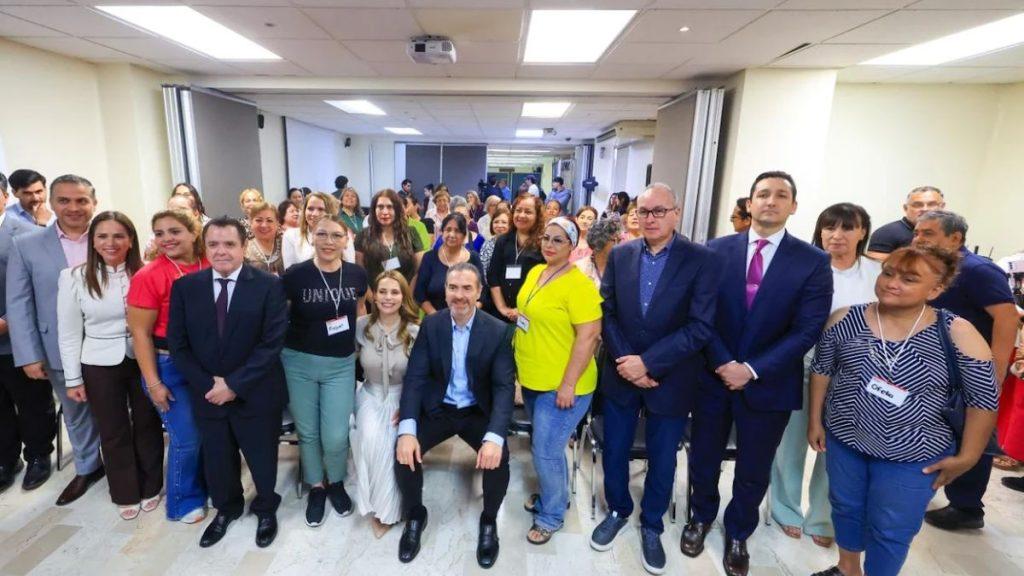 Large group of professionals posing for a group photo in a bright conference room with name badges visible on many attendees   Informe Regio