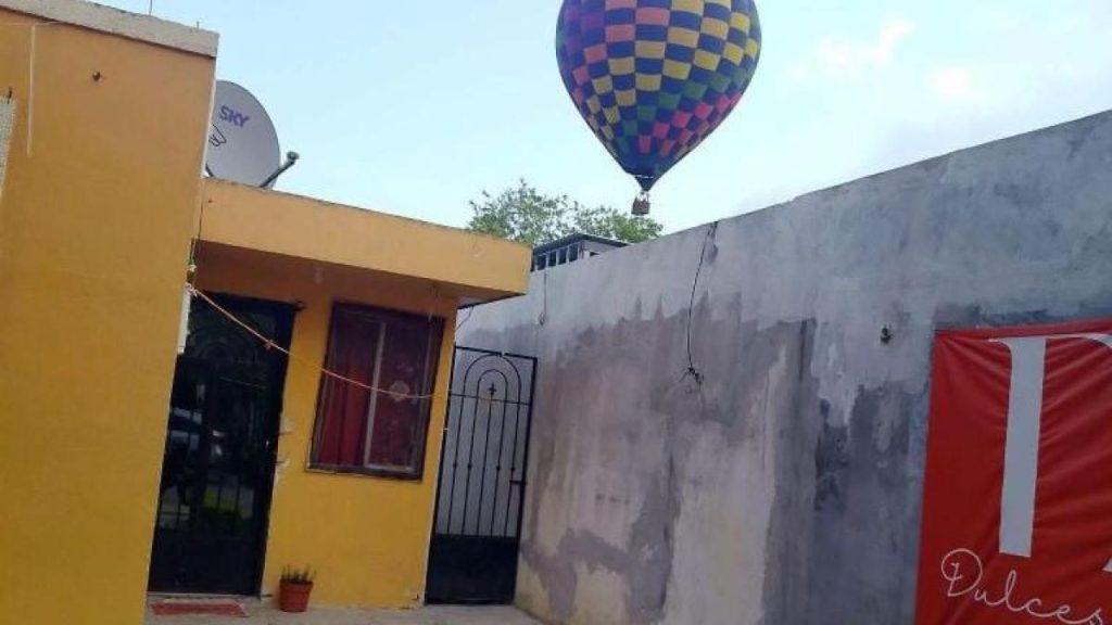 Colorful hot air balloon over a yellow building and gray wall in a sunny courtyard   Informe Regio