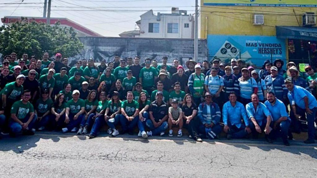 Large group of people in green T shirts and blue uniforms posing for a group photo on a street   Informe Regio