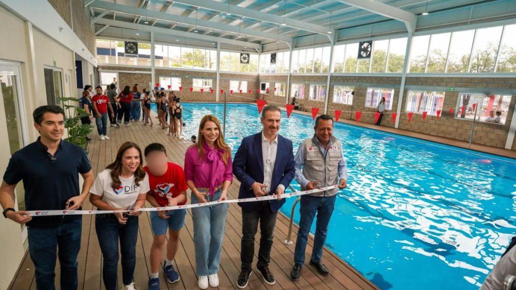 Group of six adults cutting a ribbon at the edge of an indoor swimming pool during a ceremony with onlookers in the background   Informe Regio