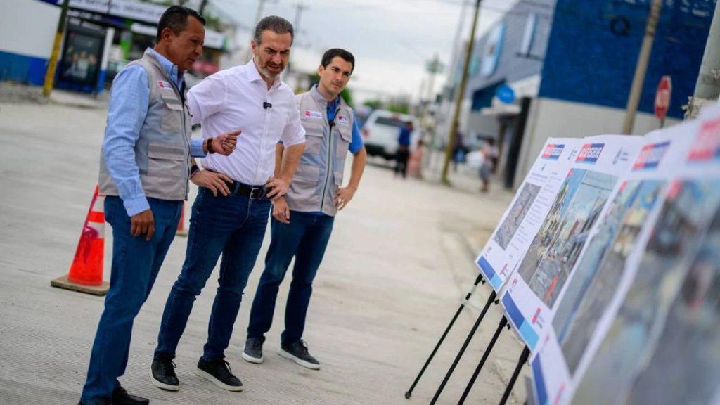 Three men in a street setting study large planning boards or maps on stands discussing a project with one man in a white shirt taking the lead   Informe Regio