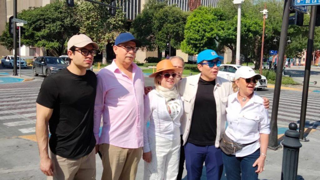 Group of five adults posing together on a city street crosswalk smiling at the camera   Informe Regio