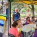 Row of colorful recycling bins beside a market style seating area as volunteers run a park event under a canopy   Informe Regio