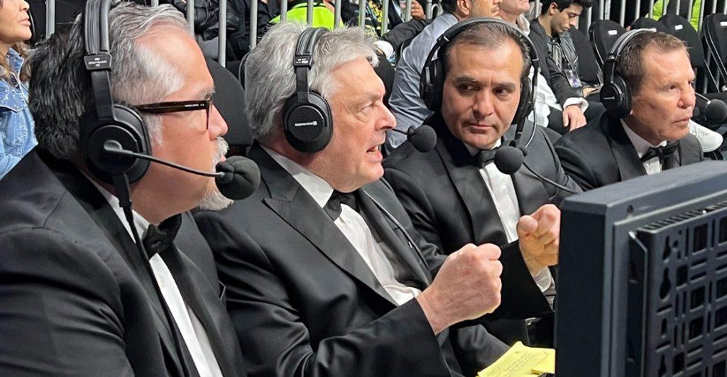 Four men in black tuxedos with headsets and microphones commentating at a broadcast table by a monitor   Informe Regio