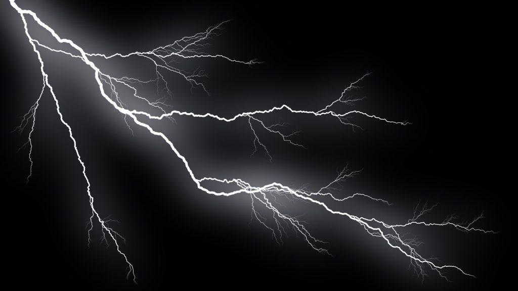 White lightning bolts streak across a dark night sky with a stormy glow around them   Informe Regio