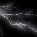 White lightning bolts streak across a dark night sky with a stormy glow around them   Informe Regio