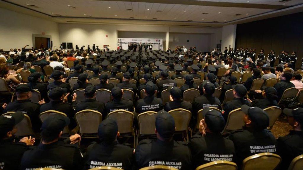 Policía-de-monterrey-166-policías-adrián-de-la-garza - Informe Regio Large auditorium filled with uniformed guards seated facing a stage at a graduation ceremony Informe Regio