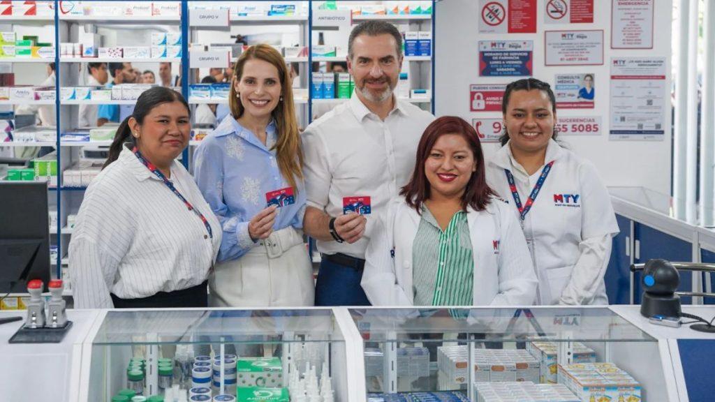 Five pharmacy staff posing behind a counter in a drugstore holding red cards and smiling at the camera bold shelves of medications in background   Informe Regio