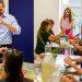 Split image left shows a man in a light blue shirt forming a heart with his hands while a child sits at a table with colorful letters right shows a group crafting at a long table with a facilitator nearby   Informe Regio