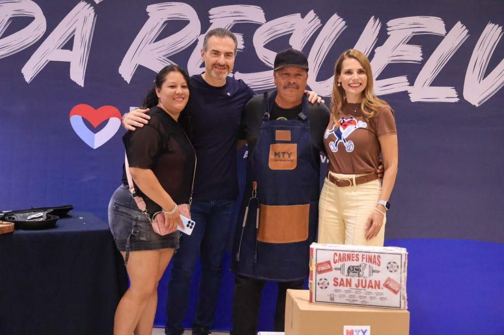 Whatsapp Image 2026-06-22 at 105259 Am 2 - Informe Regio Four people pose together on a stage in front of a banner with a man in a blue apron center and two women on either side smiling for the photo Informe Regio