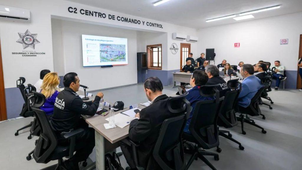 Police and officials seated around a long conference table in a command center facing a wall screen with a map   Informe Regio