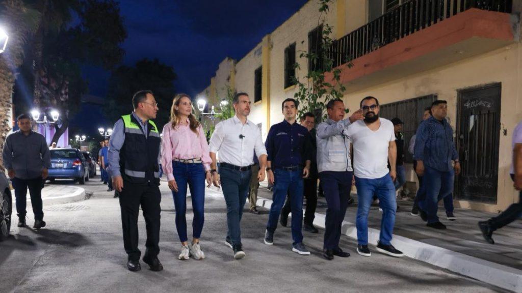 Group of officials walking down a lit street at night some in vests discussing as they stroll together   Informe Regio