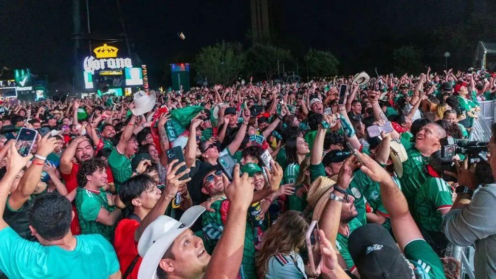 Large crowd at a nighttime outdoor event many fans wearing green jerseys and raising phones to capture the moment   Informe Regio