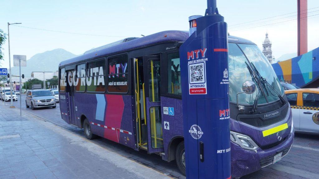 Purple MTY bus with open door parked along a sidewalk in an urban street setting cars in the background   Informe Regio