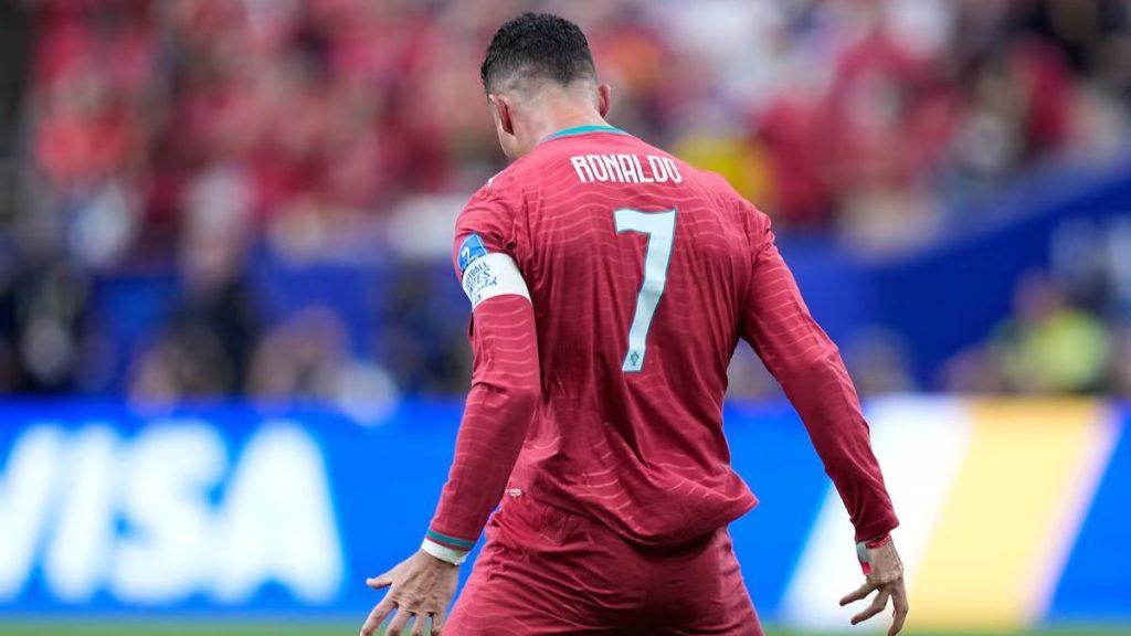 Portuguese footballer seen from behind in red kit with number 7 and captain armband on his left arm during a match   Informe Regio