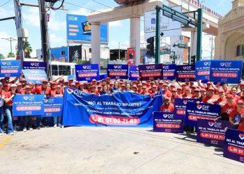 Prevenir-el-trabajo-infantil-en-monterrey - Informe Regio Group of volunteers in red shirts posing on a city street holding blue signs that say NO AL TRABAJO INFANTIL and a central blue banner about ending child labor with a red hotline number visible in the middle of the crowd Informe Regio