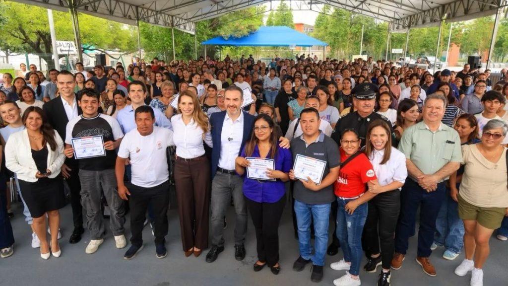 Quienes-pueden-inscribirse-al-programa-maneja-seguro - Informe Regio Large group of people posing with certificates at an outdoor ceremony under a canopy celebrating achievements Informe Regio