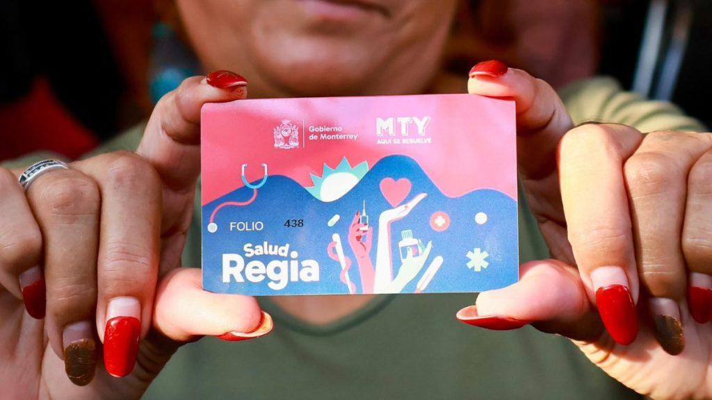 Hands with red nails holding a pink blue Salud Regia health card from Gobierno de Monterrey toward the camera   Informe Regio