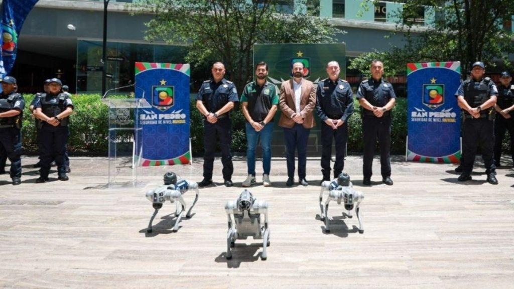 Police officers and a man in a tan blazer stand behind four robotic dog units on a paved plaza during a robotics unveiling or press event with banners in the background   Informe Regio