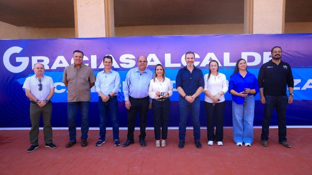 Nine adults posing in a row in front of a purple banner at an outdoor event   group photo with a large backdrop saying thanks or similar text     Informe Regio