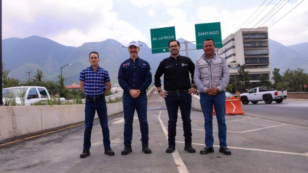 Adrian-de-la-garza 1 - Informe Regio Four men stand on a road with distant mountains posing for a photo under green directional signs reading AV LA RIOJA and SANTIAGO Informe Regio