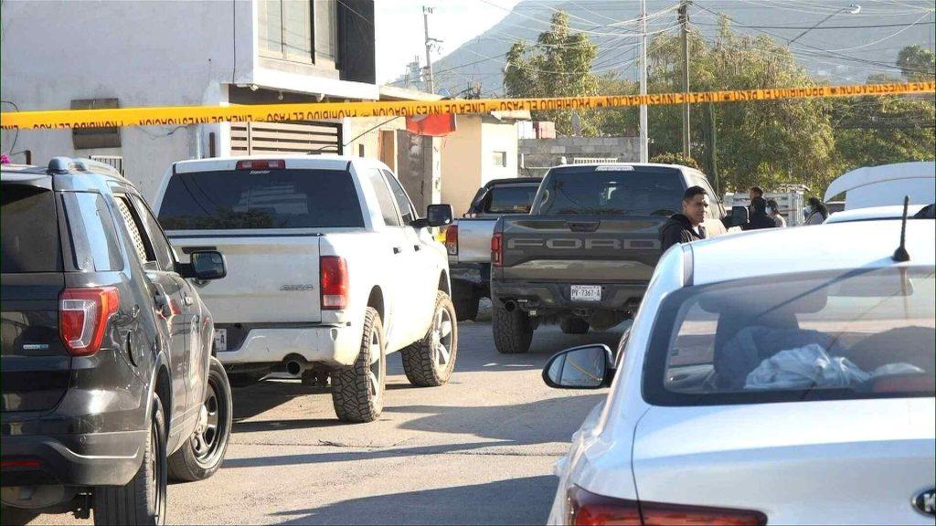Caso-britany-naomi-nuevo-león - Informe Regio Residential street scene with several parked trucks and cars orange caution tape stretched across the scene and people in the background near a building Informe Regio