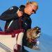 Haaland-animal-disecado-mapache-noruega - Informe Regio Traveler in sunglasses disembarks a plane with a large beige and burgundy tote bag a small raccoon sits in a carrier beside them Informe Regio
