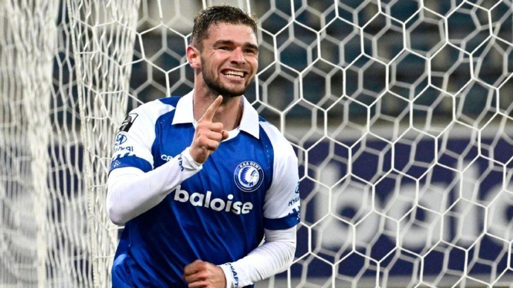Soccer player in a blue and white kit celebrating a goal raising one finger beside a netted goal post   Informe Regio
