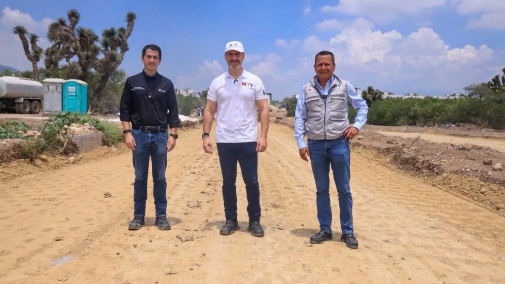 Three men in work gear stand on a dusty construction road under a blue sky with clouds posing for a photo   Informe Regio