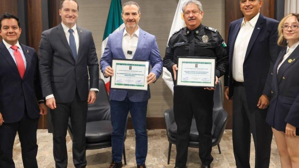 Seguridad-en-monterrey 1 - Informe Regio Group of formally dressed people posing for a ceremony two men hold framed certificates with flags in the background Informe Regio
