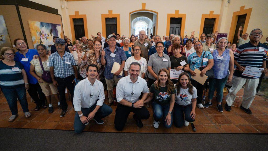 Large group of men and women posing for a group photo in a hall many wearing name tags and lanyards smiling at the camera   Informe Regio