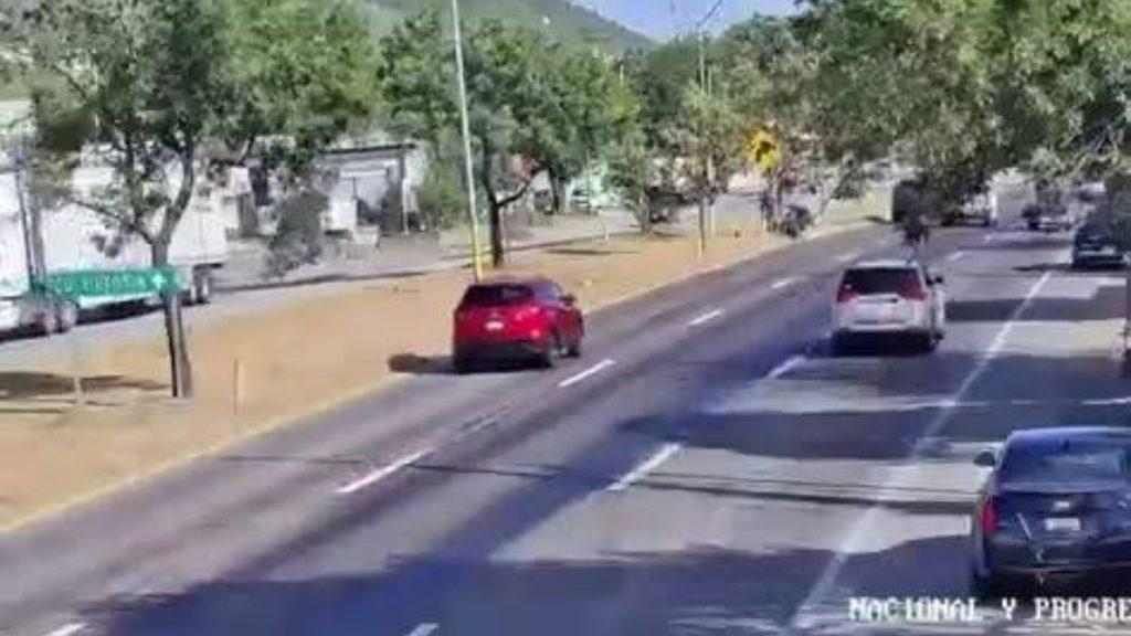 A sunny street with cars in multiple lanes red hatchback in the left lane and green trees along the sidewalk   Informe Regio