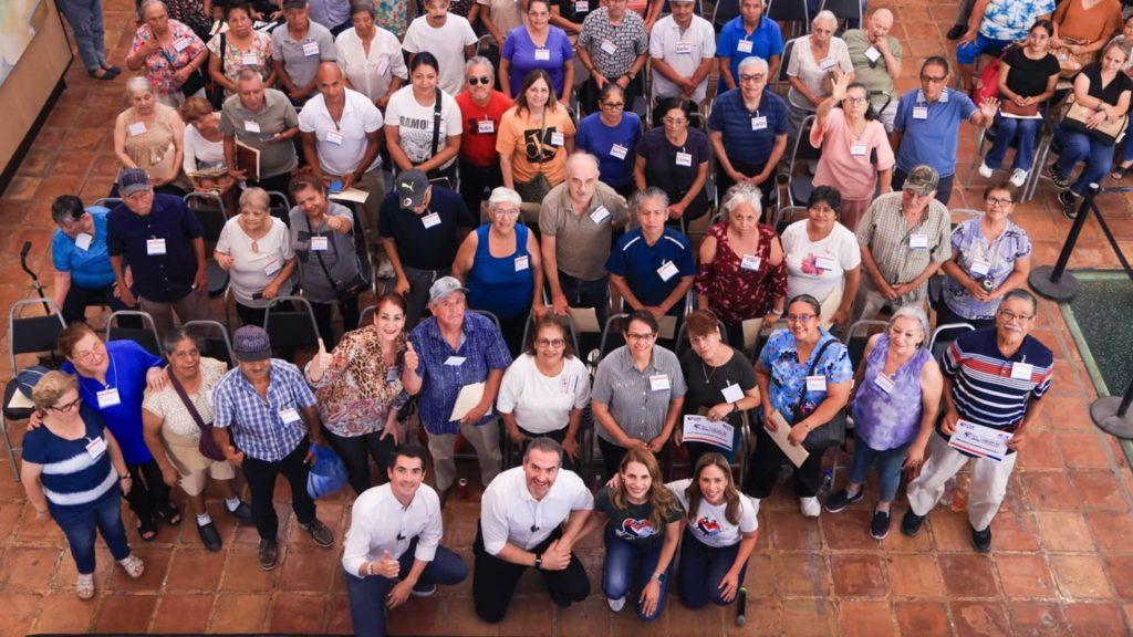 Large diverse group of adults posing for a high angle group photo in a tiled indoor venue all wearing name badges   Informe Regio