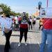 Group of people marching on a street holding large missing person or identification flyers sunny day storefronts visible in background   Informe Regio