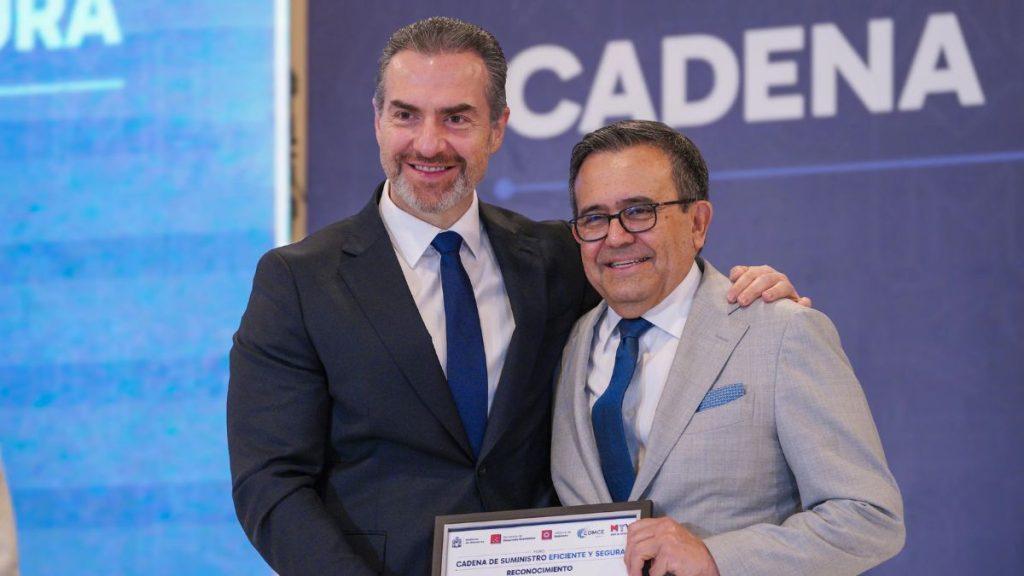 Gobierno-monterrey-impulsa-comercio-exterior - Informe Regio Two men in suits smile and pose together at an awards event one holding a framed certificate Informe Regio