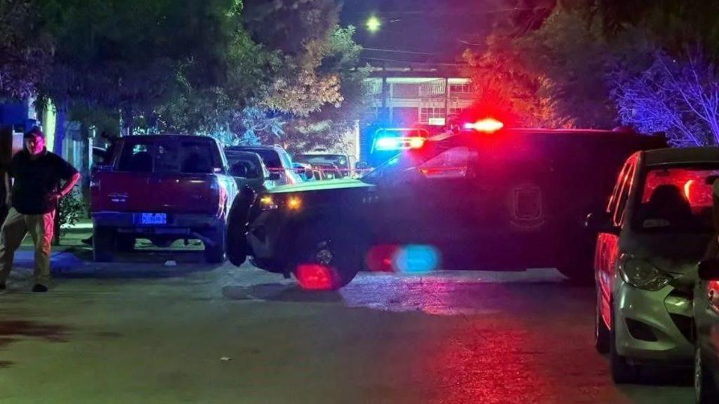 Nighttime street scene with police cars flashing red and blue lights bystanders nearby   Informe Regio