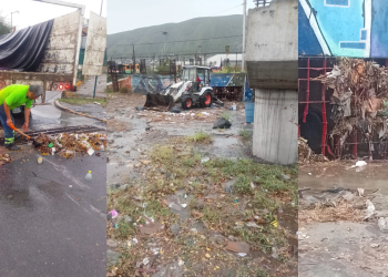 Worker in a neon shirt shovels trash from a wet street beside a dump truck debris scattered on the road   Informe Regio