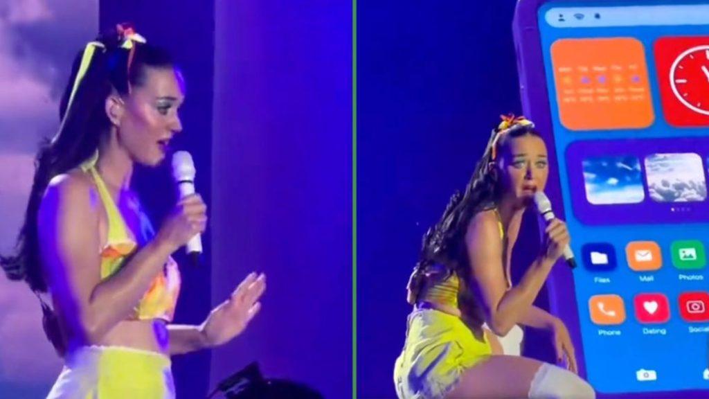 Female singer in a neon yellow outfit sings into a microphone on stage with a large smartphone prop in the blue lit background   Informe Regio