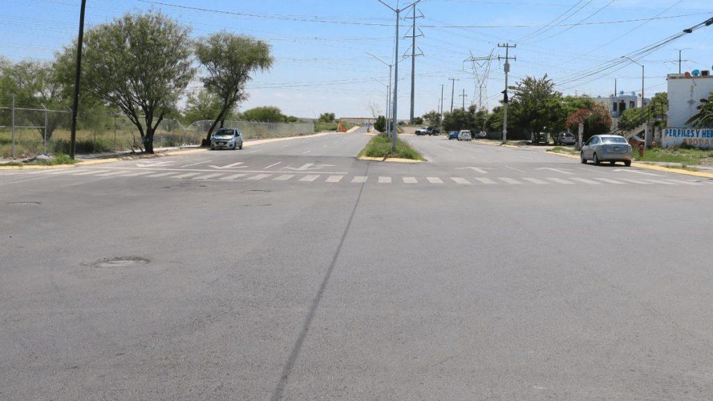 Municipio-de-apodaca-aeropuerto - Informe Regio Wide street intersection with a central grassy median crosswalks and cars parked along both sides under a clear blue sky Informe Regio
