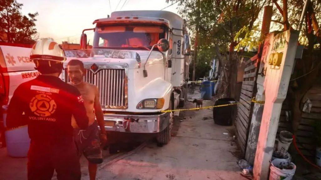 Salinas-victoria-niño-quemado - Informe Regio Volunteer firefighter in a helmet talks to a shirtless man beside a large white truck with yellow caution tape across a yard at dusk Informe Regio