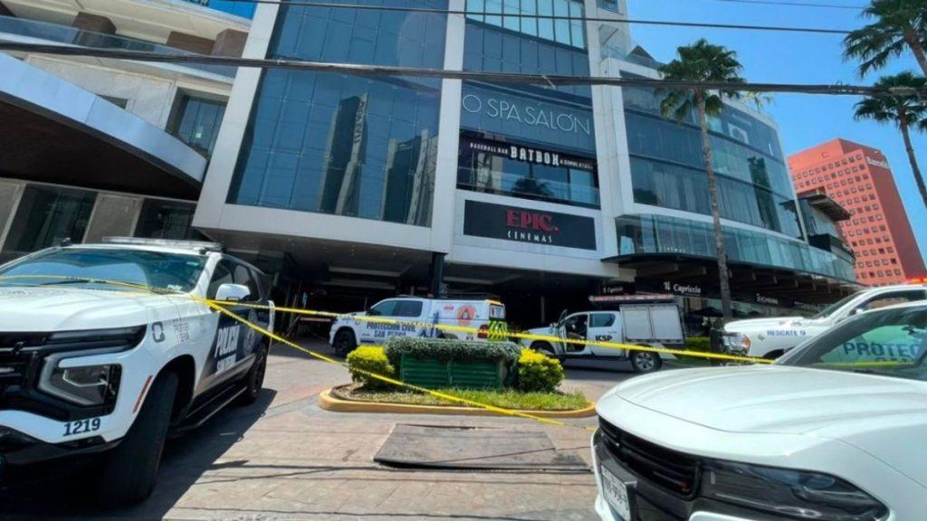 San-pedro-feminicidio-hotel-safi - Informe Regio Police cars and yellow caution tape cordon off a shopping center entrance with Epic Cinemas sign visible suggesting an incident or investigation in progress Informe Regio