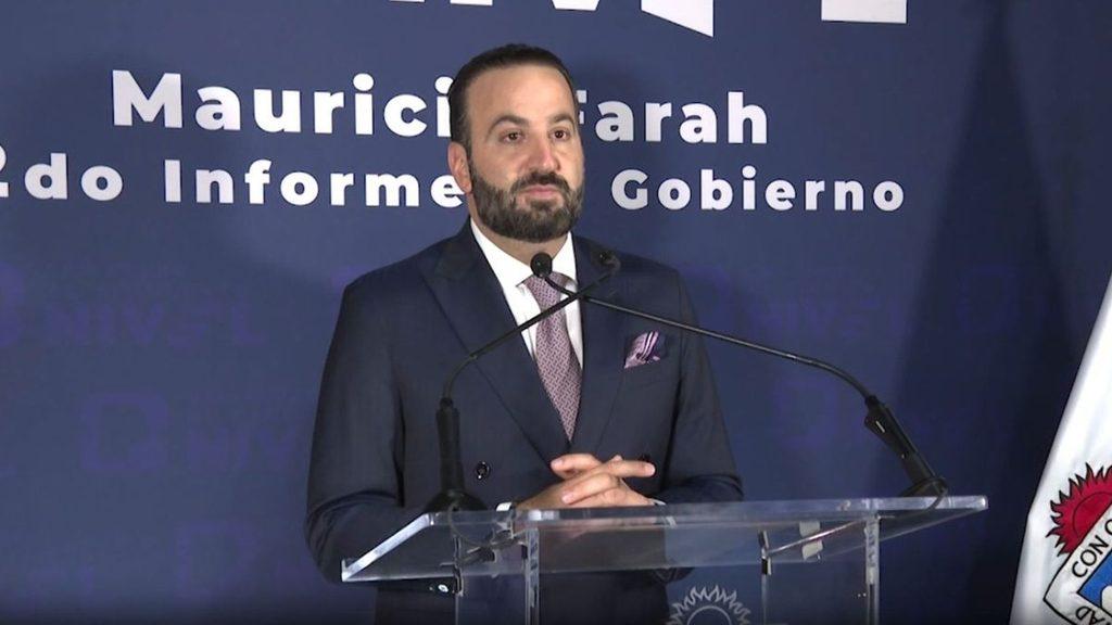 Man in a dark suit delivering a speech at a clear podium during a formal event   Informe Regio